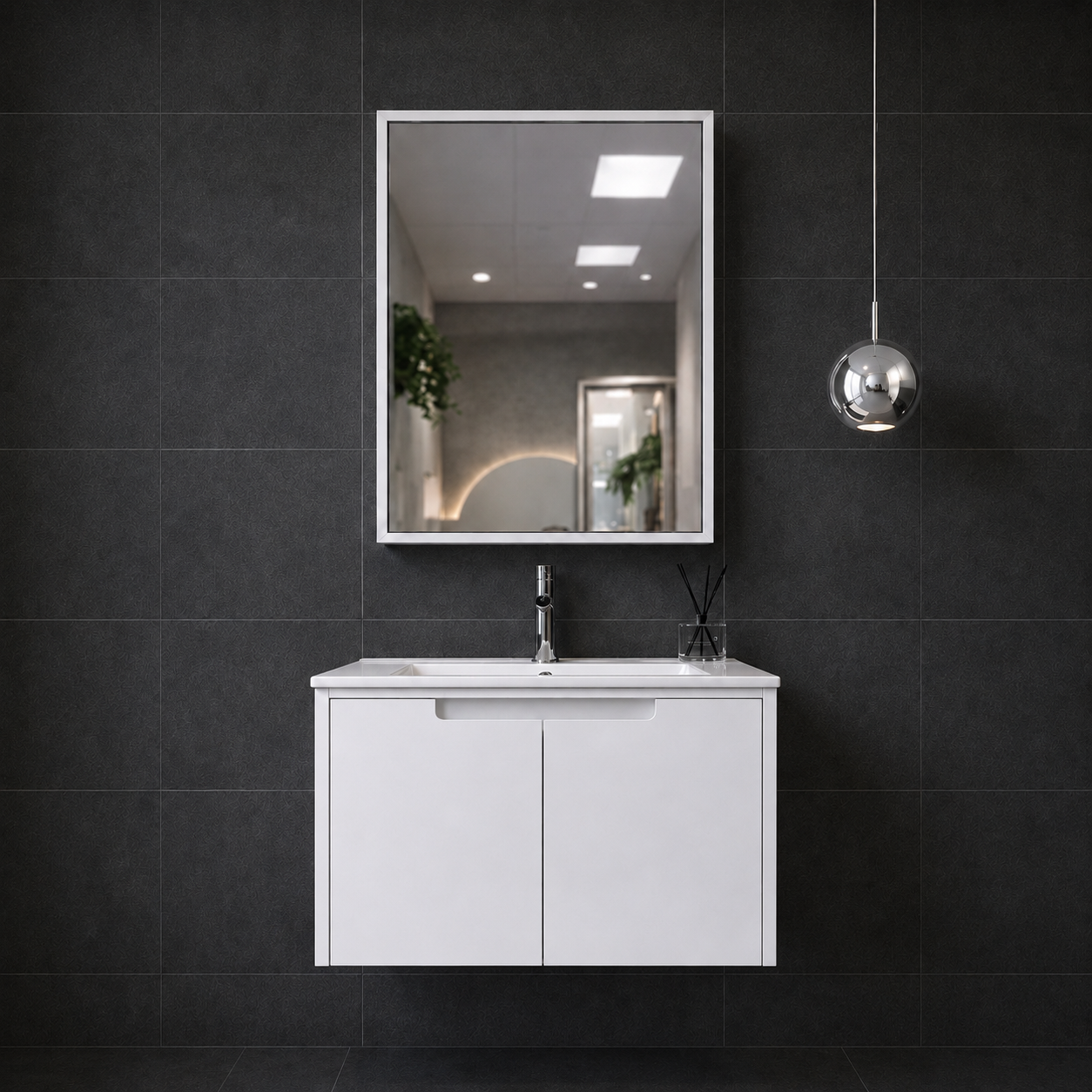 Bathroom vanity with mirror and sink against a dark tiled wall